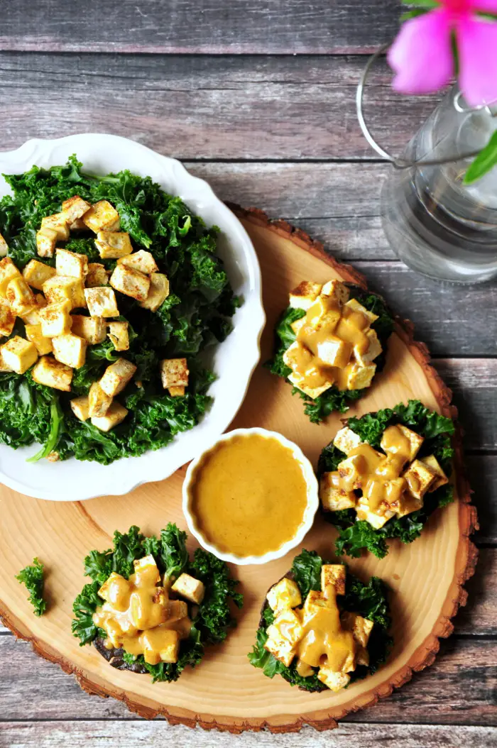 Stuffed portabella mushrooms with baked tofu and crunchy kale drizzled with a creamy cajun dressing for the win! They are vegan and gluten-free!