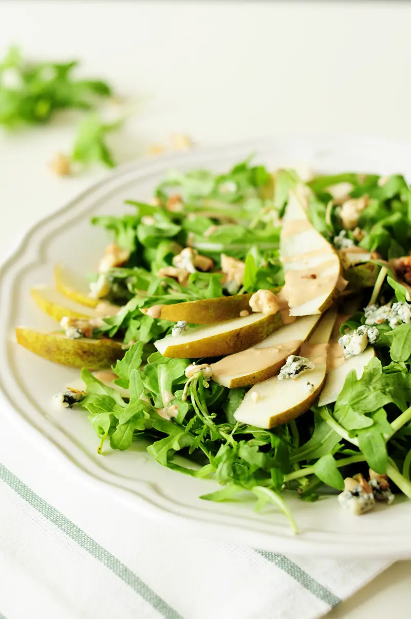 Topped with blue cheese and chopped walnuts, this four-ingredient arugula pear salad drizzled with tahini dressing is so quick to throw together, yet the combination of sweet and salty flavors and crunchy and soft textures proves that simple can be phenomenal.