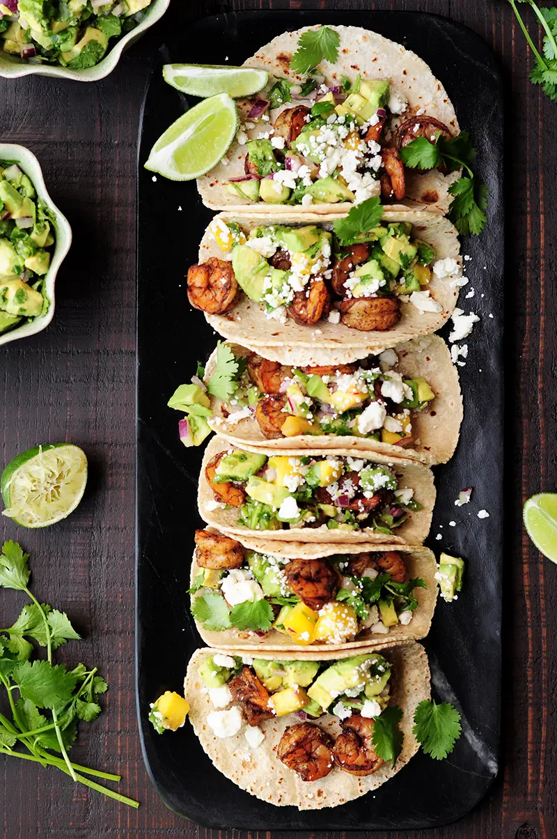 Shrimp tacos made with a homemade blackened seasoning mix, topped with refreshing mango avocado salsa and feta cheese. Yum!