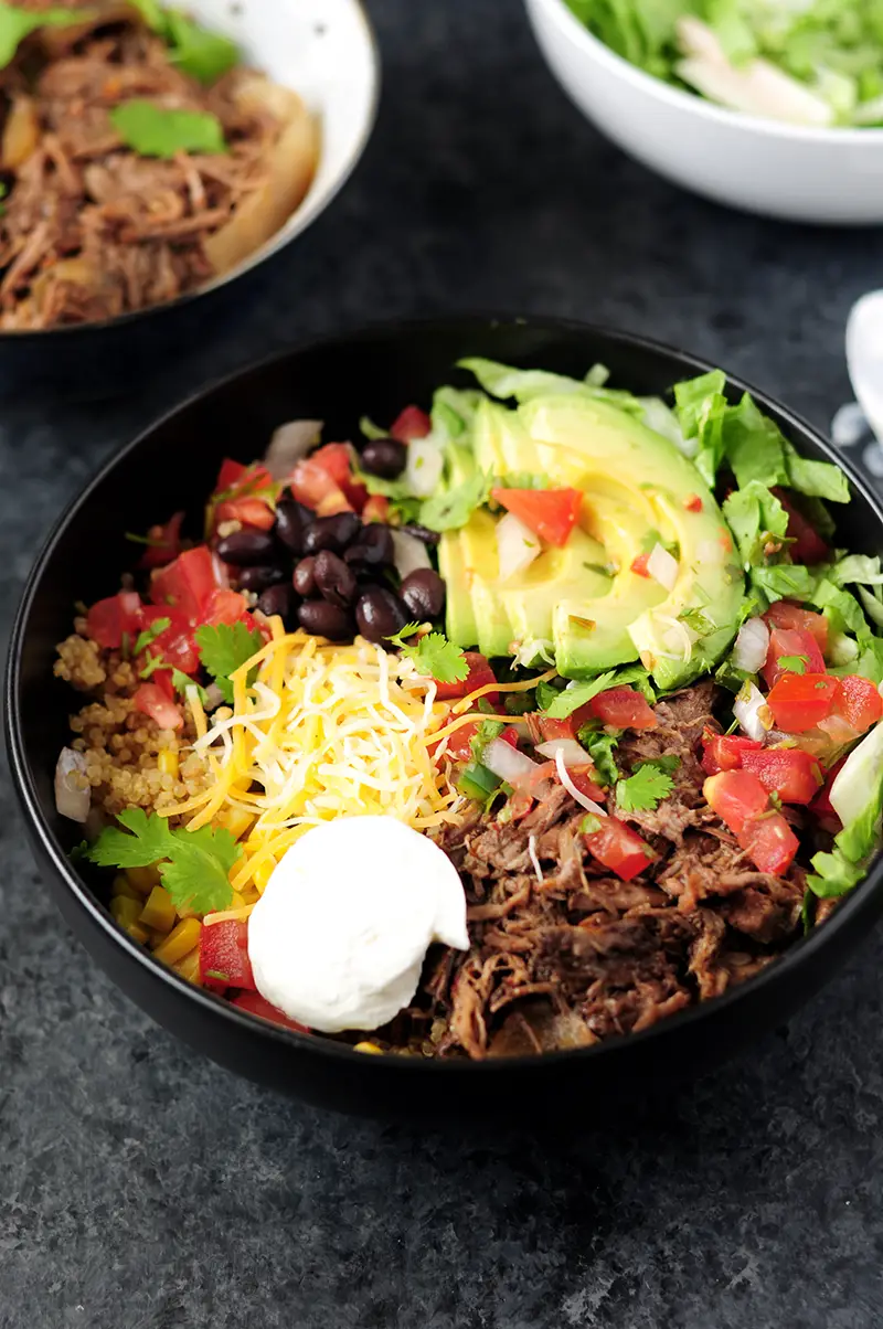 Recreate a healthy Chipotle burrito bowl in your own kitchen in just 15 minutes with slow cooker beef barbacoa and quinoa.