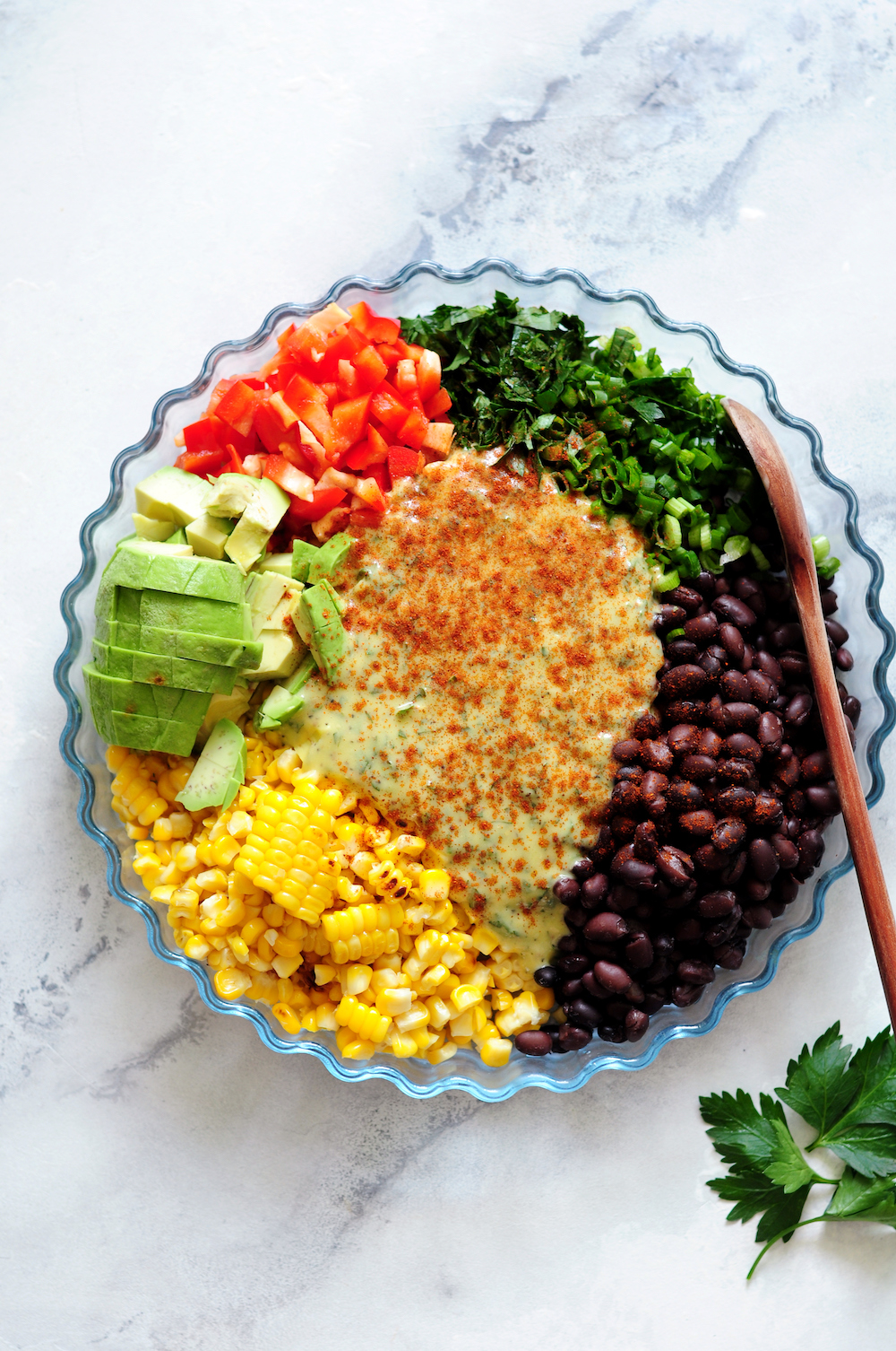 Corn and Black Bean Salad ingredients with garlic lemon aioli on top