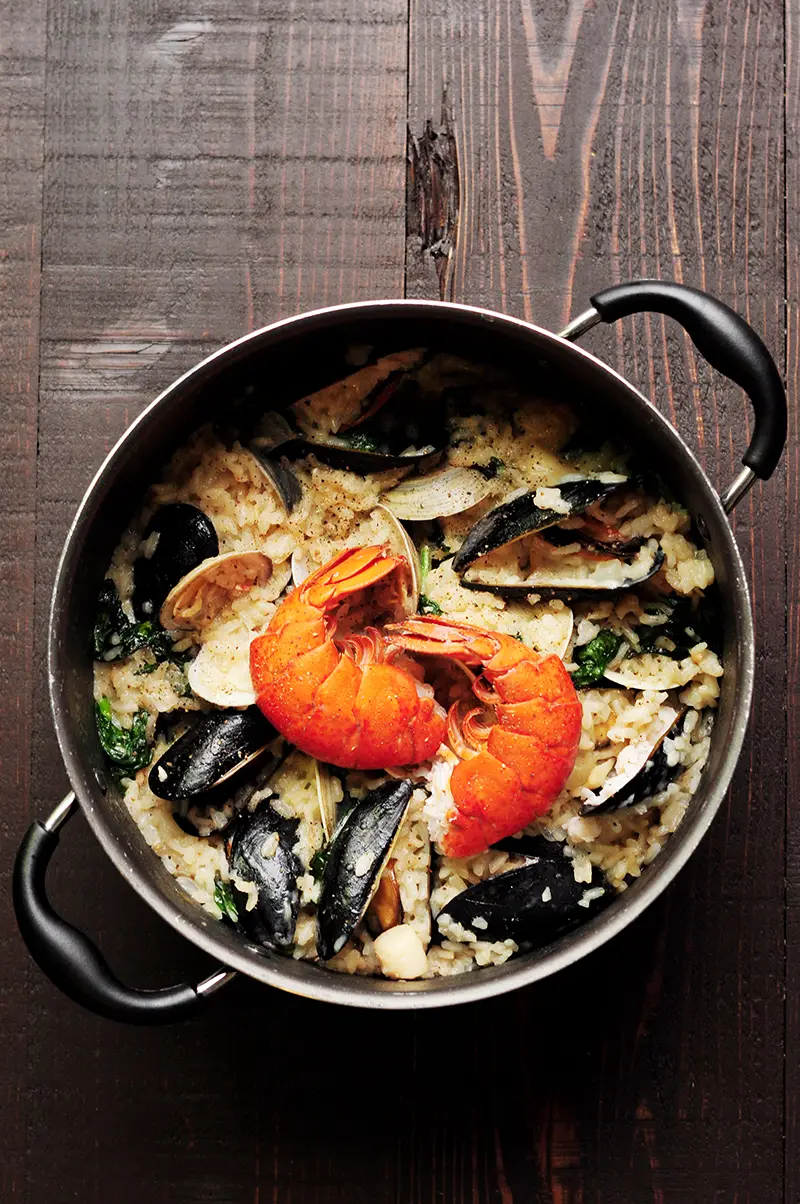 Creamy seafood risotto recipe dedicatedly simmered in lobster stock and heavy cream with clams, mussels, bay scallops, lobster tails, and spinach. It's a perfect date-night-in dinner or for any special occasions.