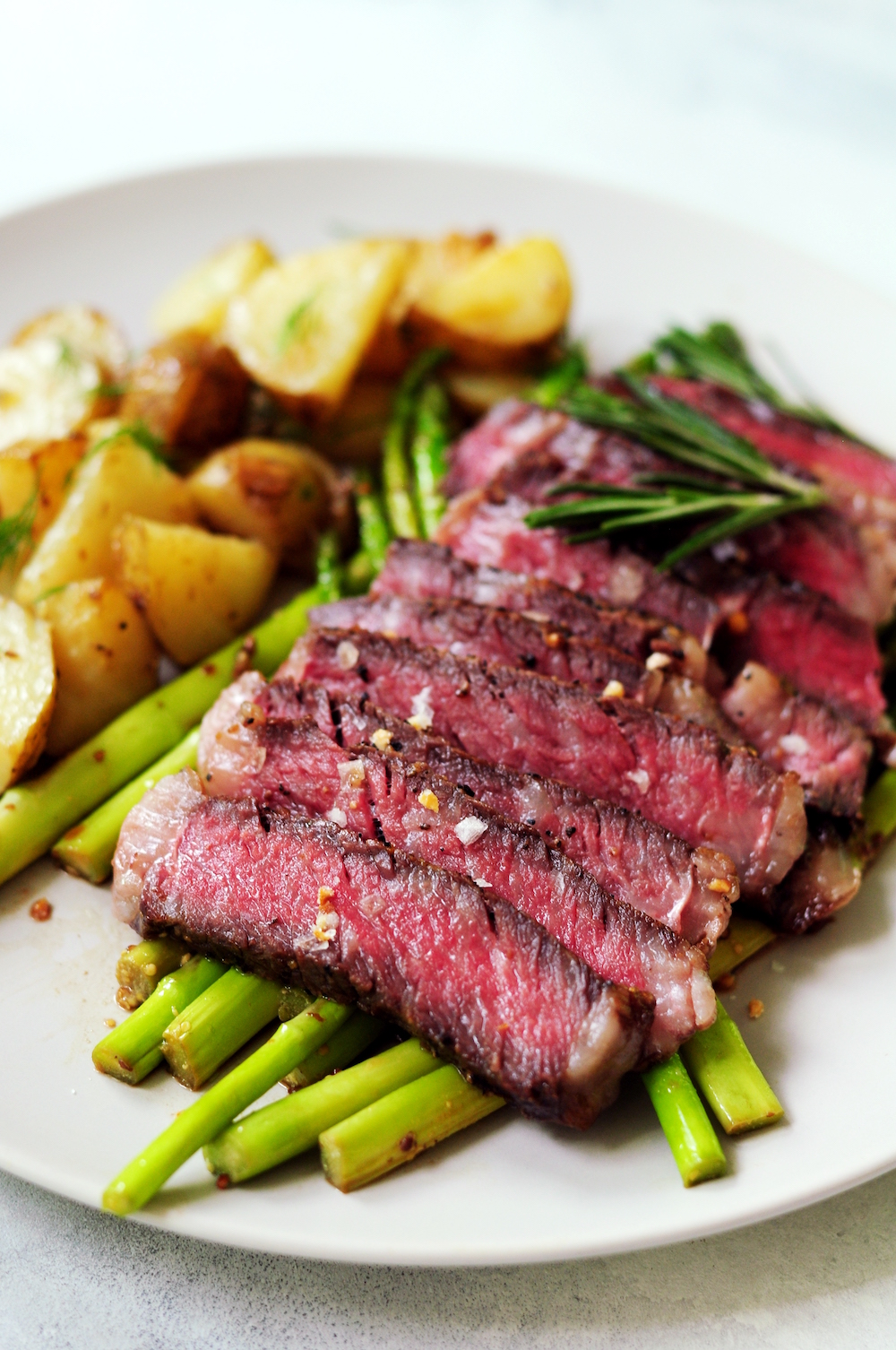 Sliced sous vide frozen steak with asparagus and potatoes