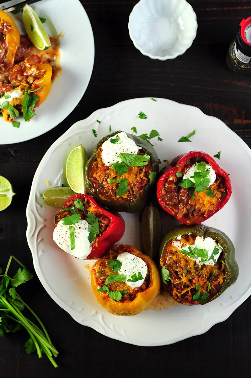 Stuffed peppers with taco-flavored ground beef, onion, tomatoes and cheddar cheese topped with avocado slices, fresh cilantro, and sour cream.