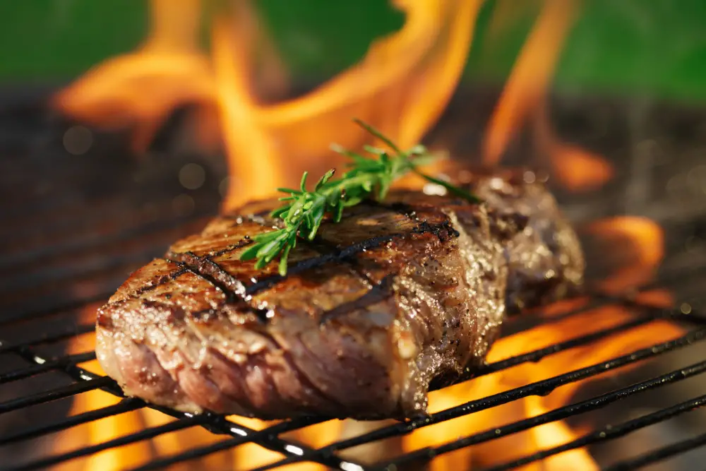 a piece of sous vide steak on the grill to finish