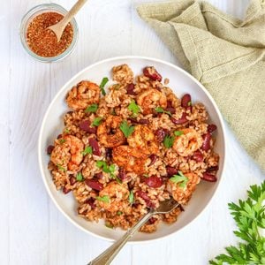 Jerk shrimp rice bowl with about 30g of protein per serving. One pan, under 15 minutes, homemade jerk seasoning, spicy kidney beans, and rice.