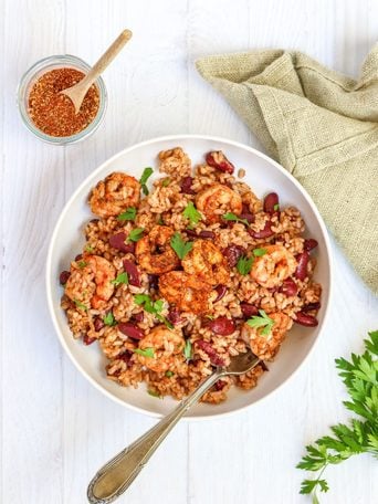 Jerk shrimp rice bowl with about 30g of protein per serving. One pan, under 15 minutes, homemade jerk seasoning, spicy kidney beans, and rice.