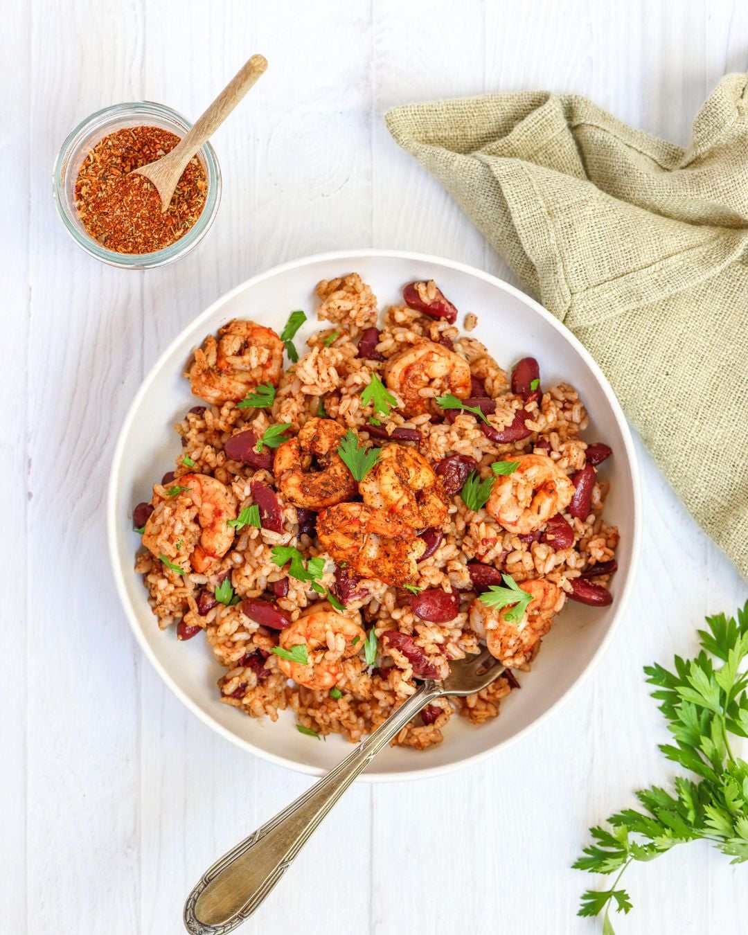 Jerk shrimp rice bowl with about 30 g of protein per serving. One pan, under 15 minutes, homemade jerk seasoning, spicy kidney beans, and rice.
