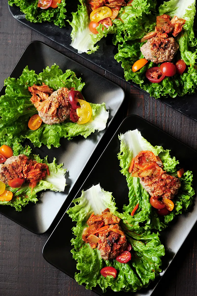 Easy lettuce wraps featuring grilled ground beef patties and kimchi. It takes less than 30 minutes to put this delicious Korean-style appetizer on the table.