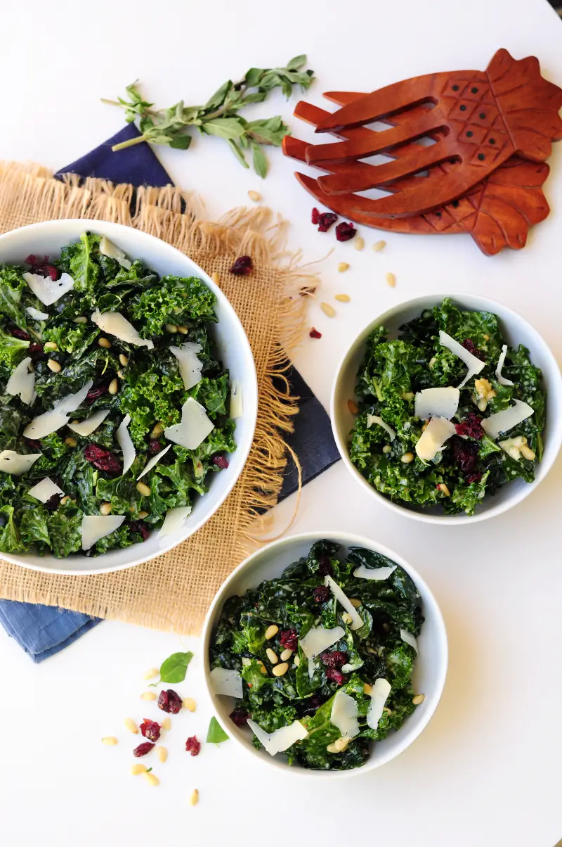 Massaged kale salad tossed with pine nuts and dried cranberries in a delightful oregano lemon salad dressing and topped with shaved Parmesan cheese. 