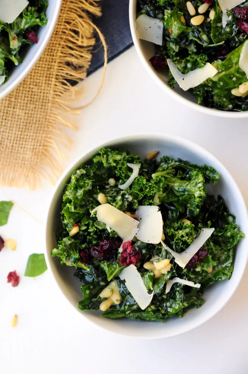 Massaged kale salad tossed with pine nuts and dried cranberries in a delightful oregano lemon salad dressing and topped with shaved Parmesan cheese. 