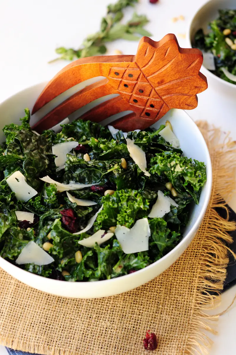 Massaged kale salad tossed with pine nuts and dried cranberries in a delightful oregano lemon salad dressing and topped with shaved Parmesan cheese. 