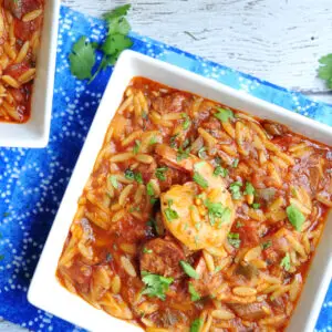 Dished one-pot jambalaya pasta featuring, Andouille sausage, chicken, shrimp, loads of veggies, and oval-shaped orzo pasta.