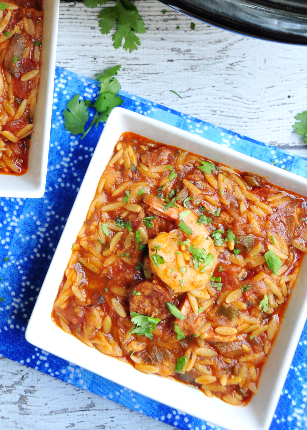 Dished one-pot jambalaya pasta featuring, Andouille sausage, chicken, shrimp, loads of veggies, and oval-shaped orzo pasta.