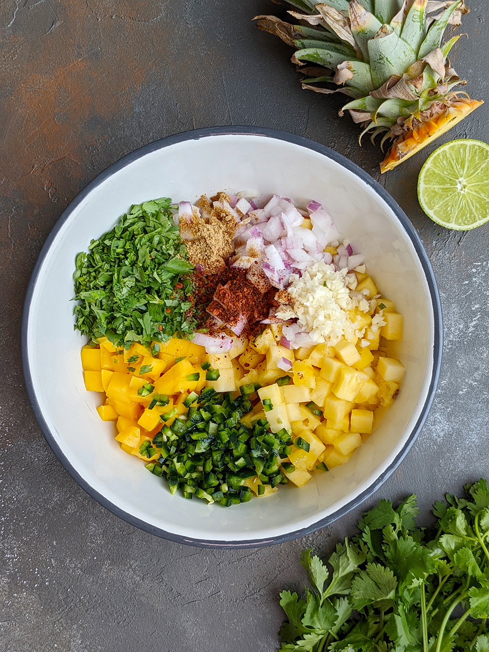 Pineapple Mango Pico de Gallo Ingredients combined in a bowl.