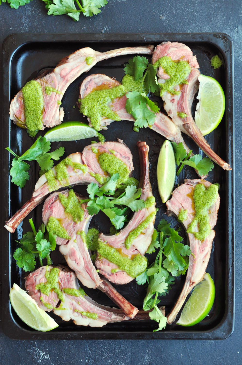 Aji verde drizzled on sous vide rack of lamb served with fresh cilantro and lime wedges