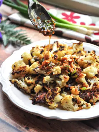 Oven-roasted Asian cauliflower that's delicious by itself, but even more intriguing with a savory soy-ginger sauce. Vegan and gluten-free friendly.