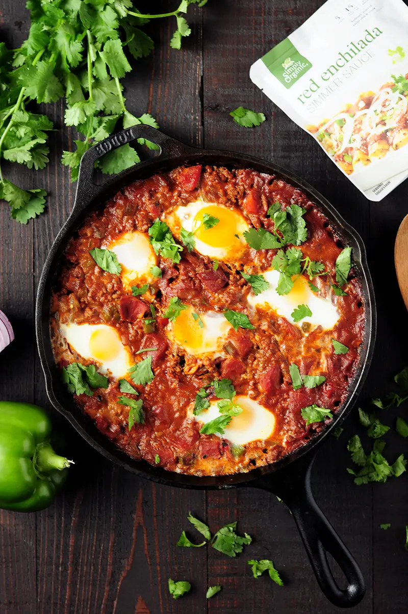Easy 7-ingredient Shakshuka recipe simmered in a tangy, aromatic red chili sauce with rich notes of cocoa, smoked paprika, and ancho chili.