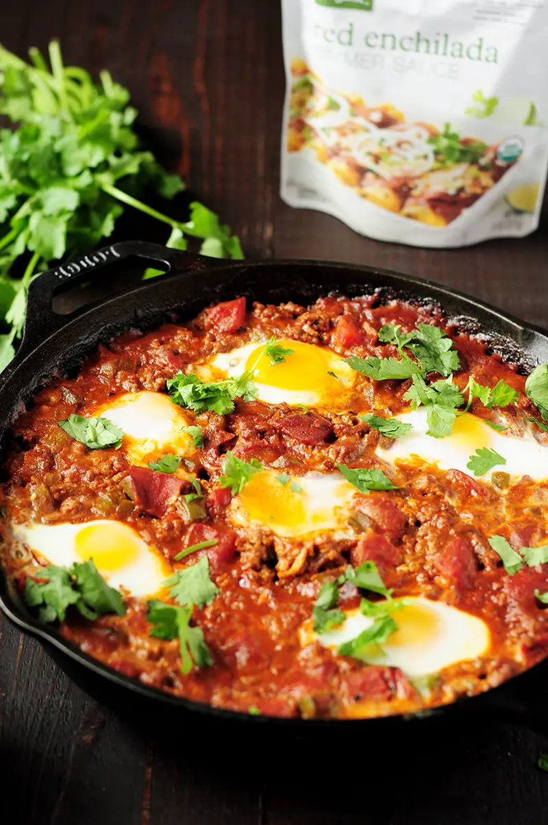 Easy 7-ingredient Shakshuka recipe simmered in a tangy, aromatic red chili sauce with rich notes of cocoa, smoked paprika, and ancho chili.