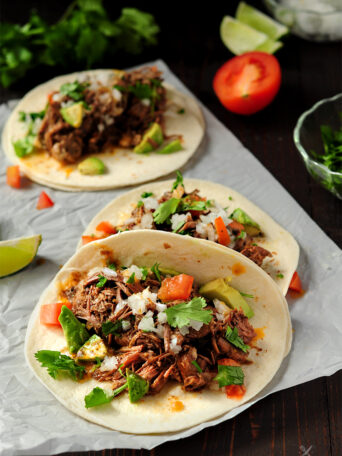 Extremely tender beef barbacoa slow-cooked in a super savory sauce. This recipe only takes 5 mins of hands-on time. Enjoy barbacoa tacos anytime!