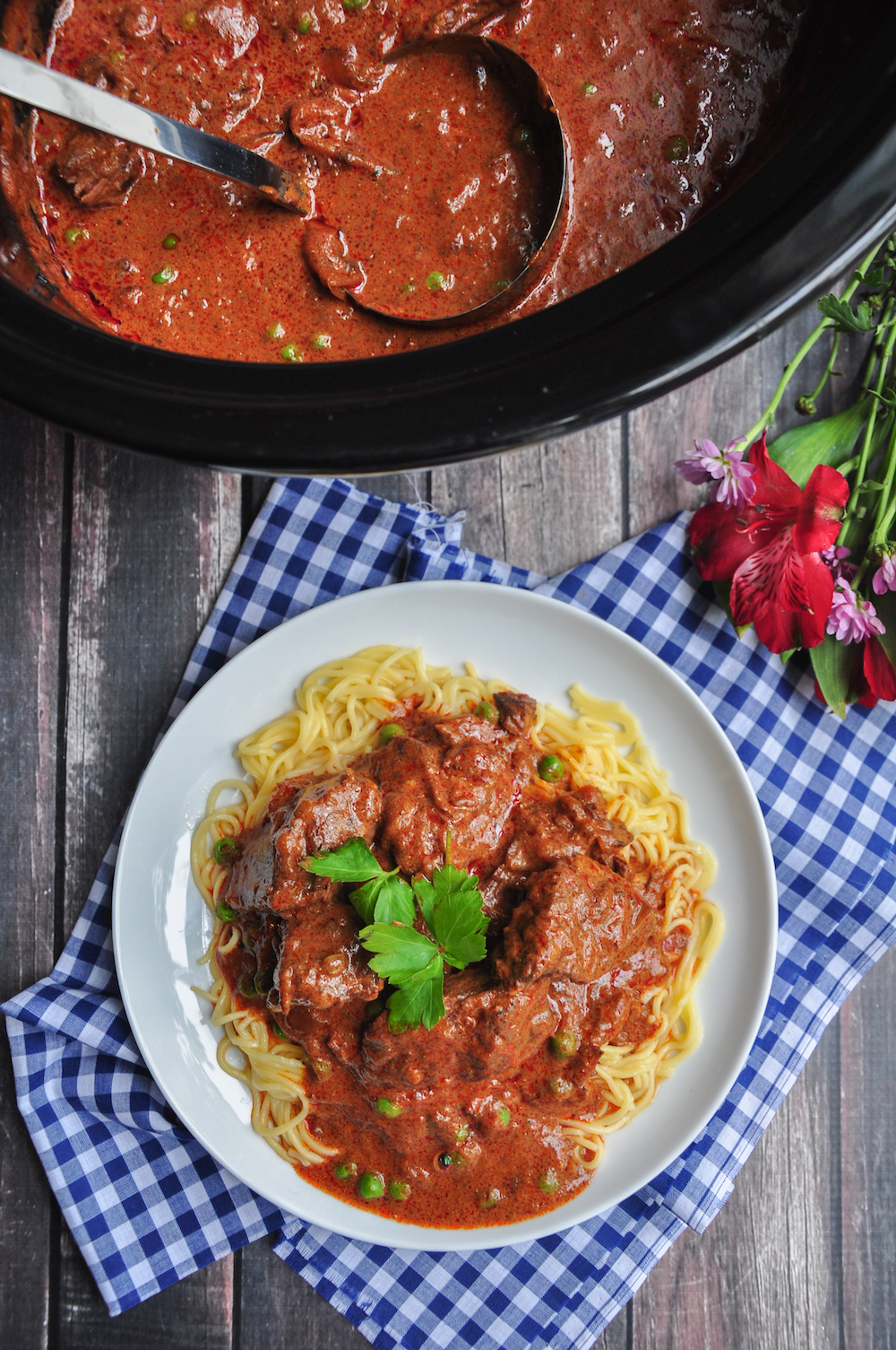 Slow cooker goulash served over egg noodles