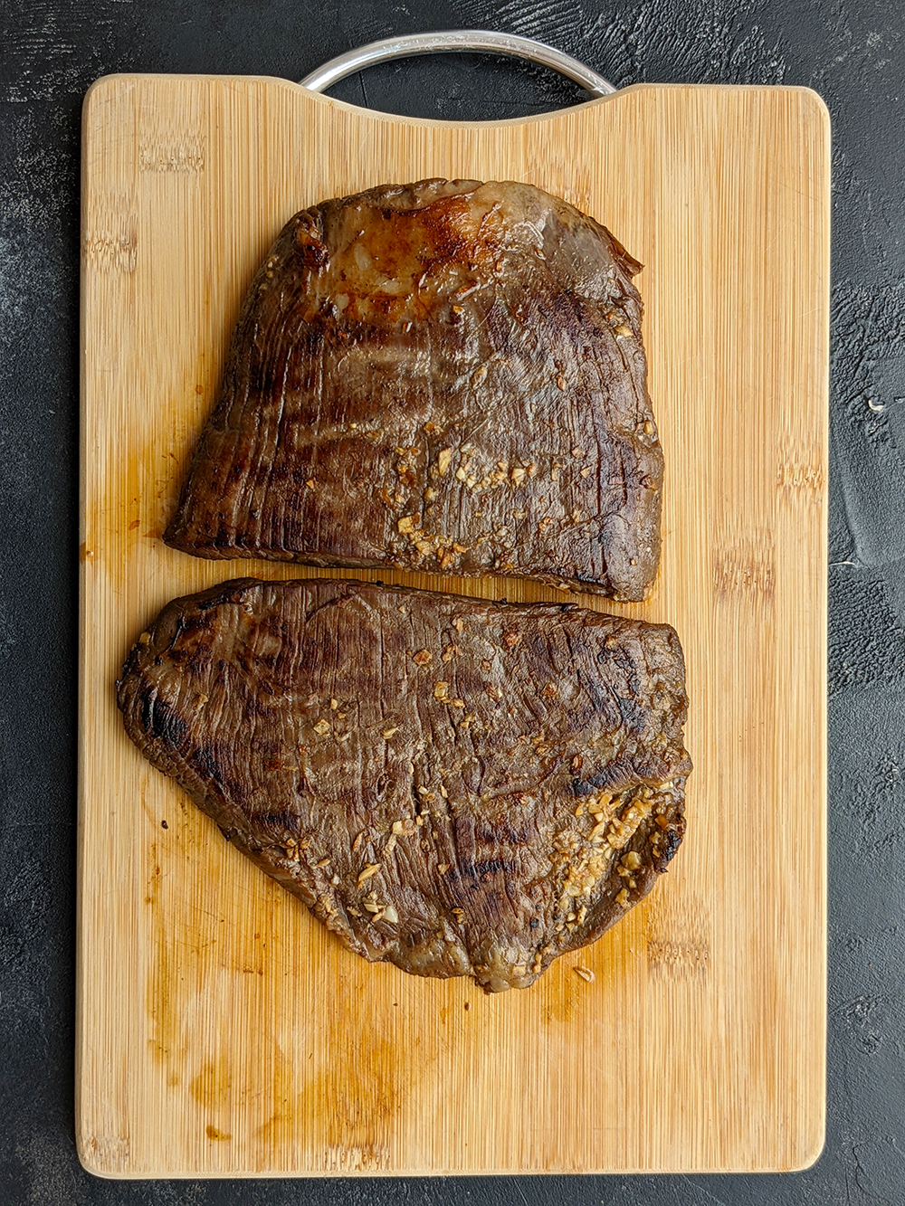 Once the timer goes off, remove the bag from the sous vide. Open the bag and transfer the steak onto a cutting board and pat it dry on both sides using paper towels. Reserve the cooking juice. Heat a cast-iron skillet over high heat until really hot, add some olive oil, and sear the steak on both sides, about one minute on each side. Transfer the nicely seared steak onto the cutting board and let it rest.
