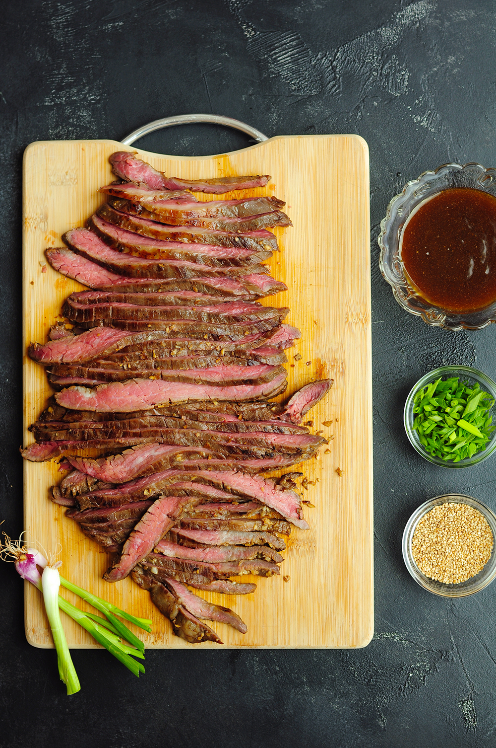 Slice the flank steak against the grain and plate it. Pour the Mongolian sauce over the steak, and garnish with green onion and toasted white sesame seeds. For a complete meal, serve with a side of vegetables and/or rice. Enjoy! 