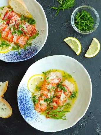 Sous vide lobster tails in shallow soup bowls