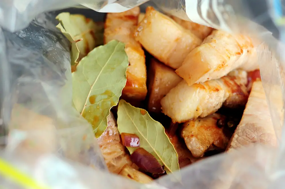 preseared pork belly with adobo sauce in a bag