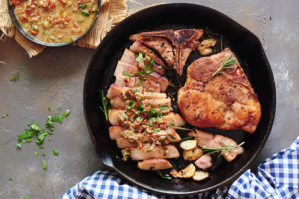 Sous vide pork chops in a cast iron skillet after searing