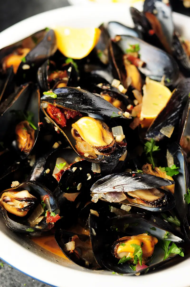Super easy mussel recipe steamed in white wine and flavor-rich chicken bone broth. Serve it as an amazing appetizer or over spaghetti as an elegant dinner. 