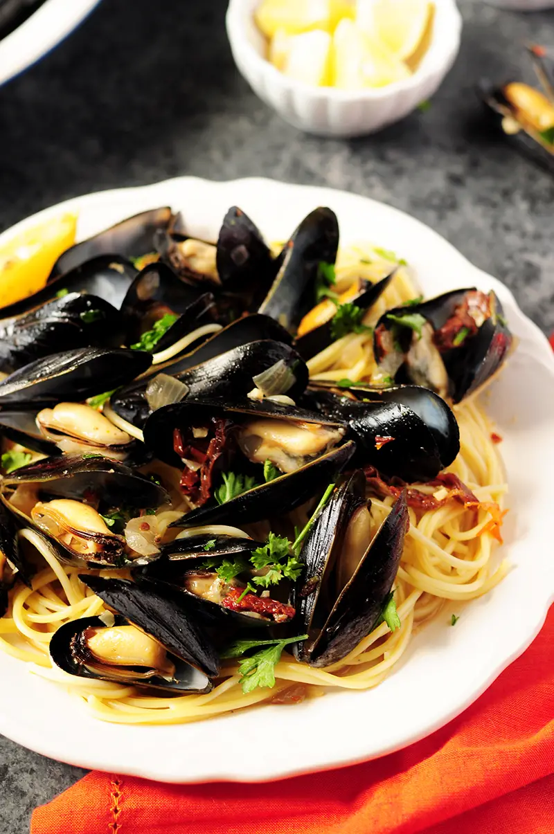 Super easy mussel recipe steamed in white wine and flavor-rich chicken bone broth. Serve it as an amazing appetizer or over spaghetti as an elegant dinner. 