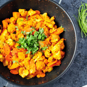 Thai red curry vegetables featuring cauliflower, sweet potatoes, carrots and onions cooked with white wine and simmered in coconut milk.