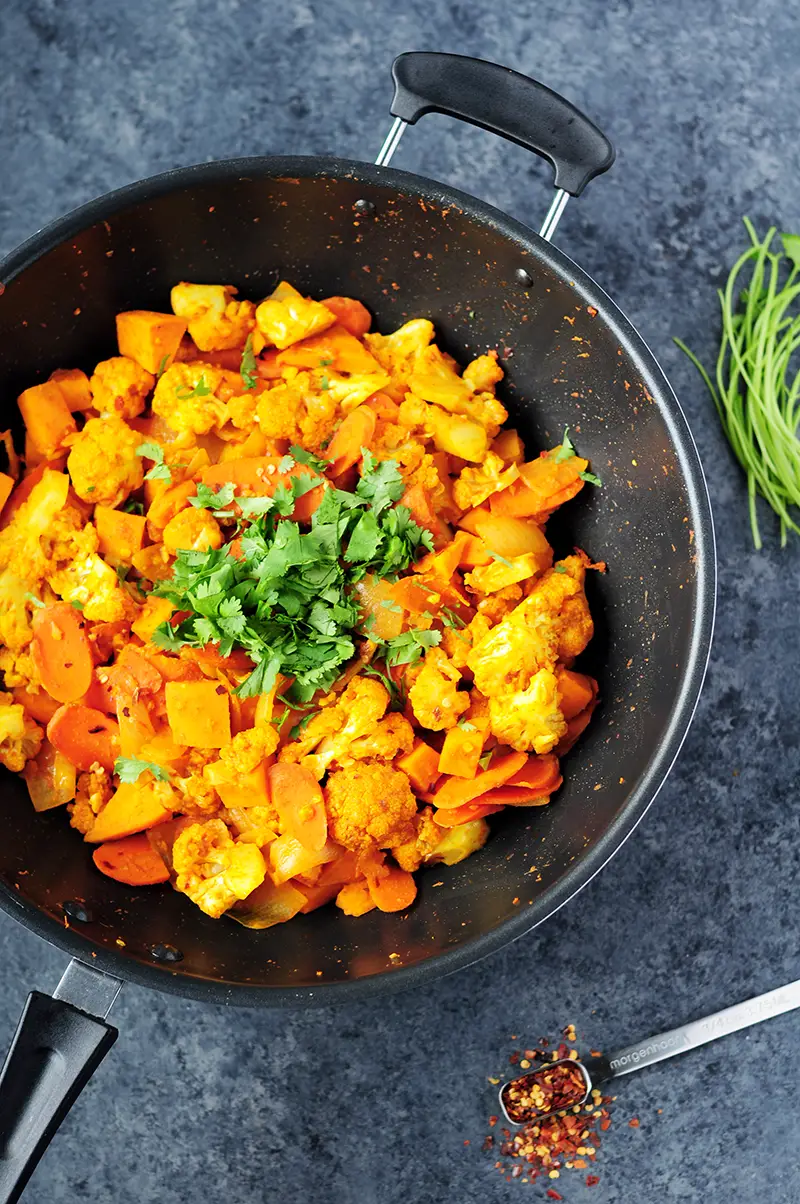 Thai red curry vegetables featuring cauliflower, sweet potatoes, carrots and onions cooked with white wine and simmered in coconut milk.